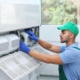 Professional technician maintaining outdoor air conditioner