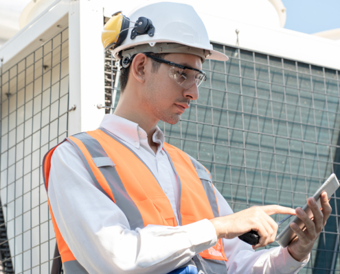 engineer using tablet computer at rooftop building construction or working checking HVAC