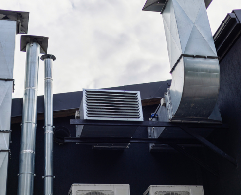 A commercial building features a complex ventilation system with silver ducts